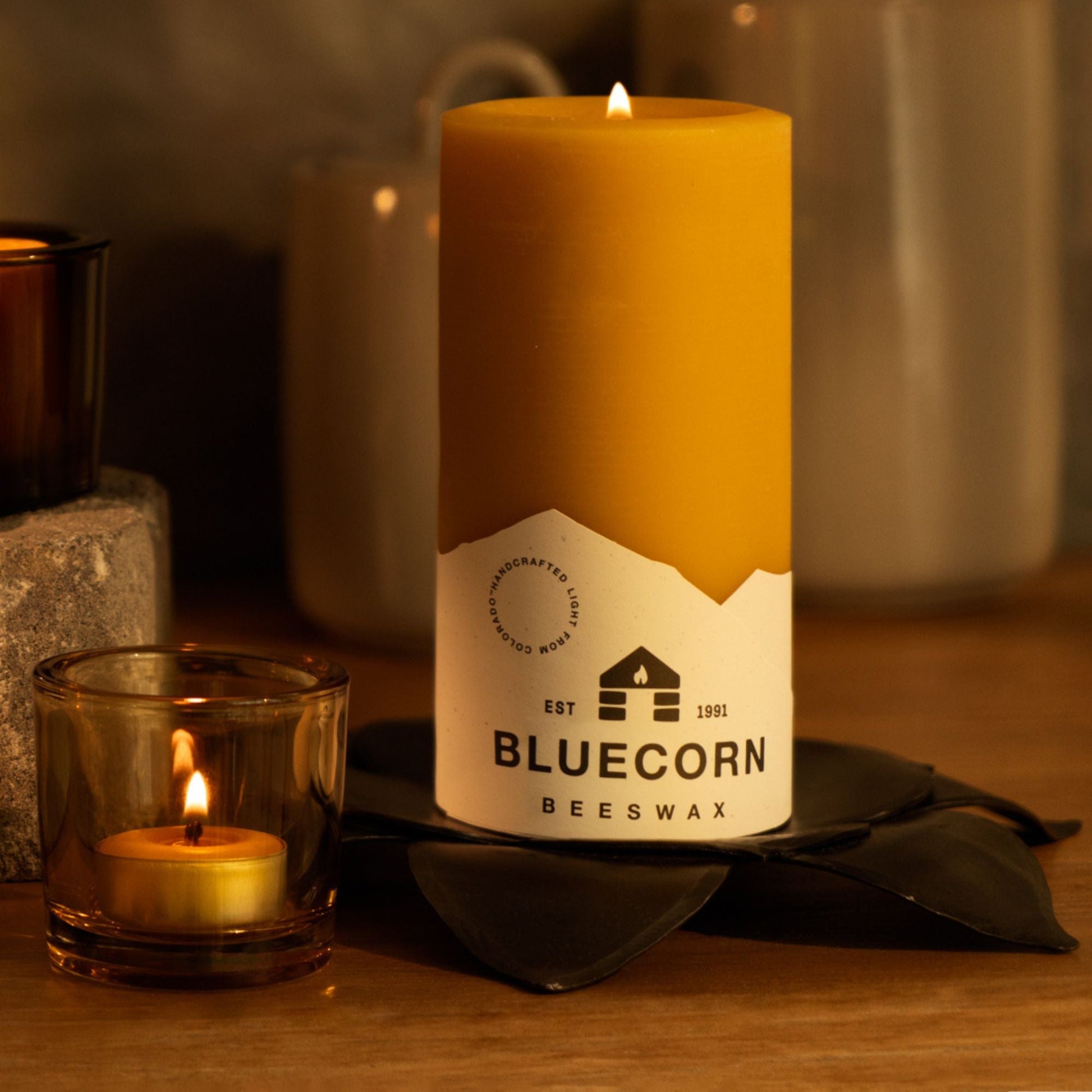 Beeswax candle with Bluecorn label on a wooden surface