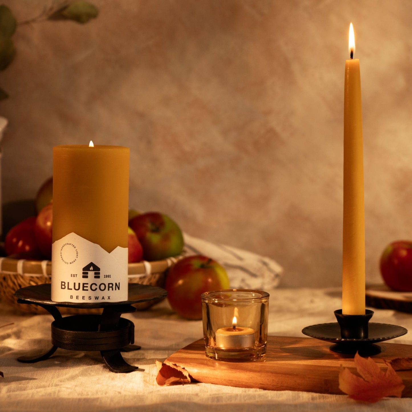 Candles on a table with apples and a blurred background