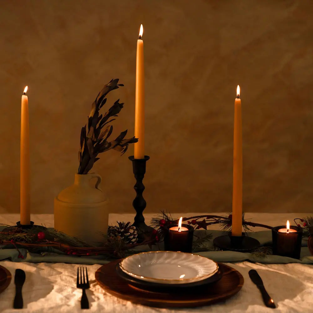 Dinner table setting with candles and decorative elements against a warm background