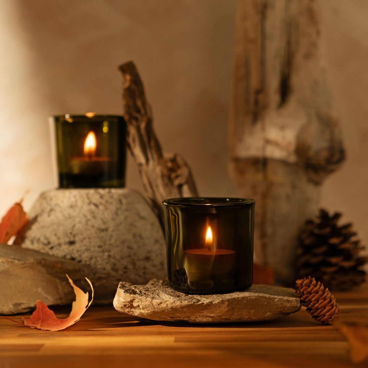 Candle in a black holder on a stone surface with a warm, cozy background.