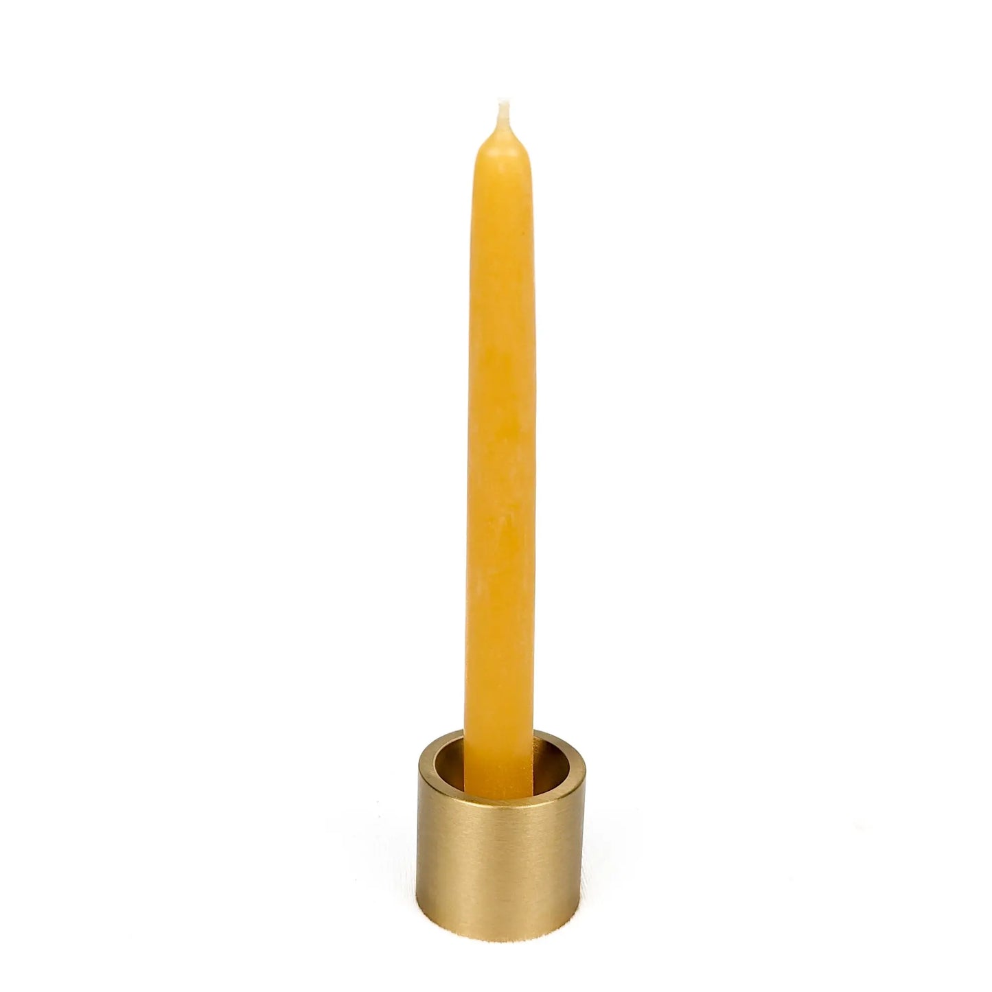 Yellow candle in a brass holder on a white background