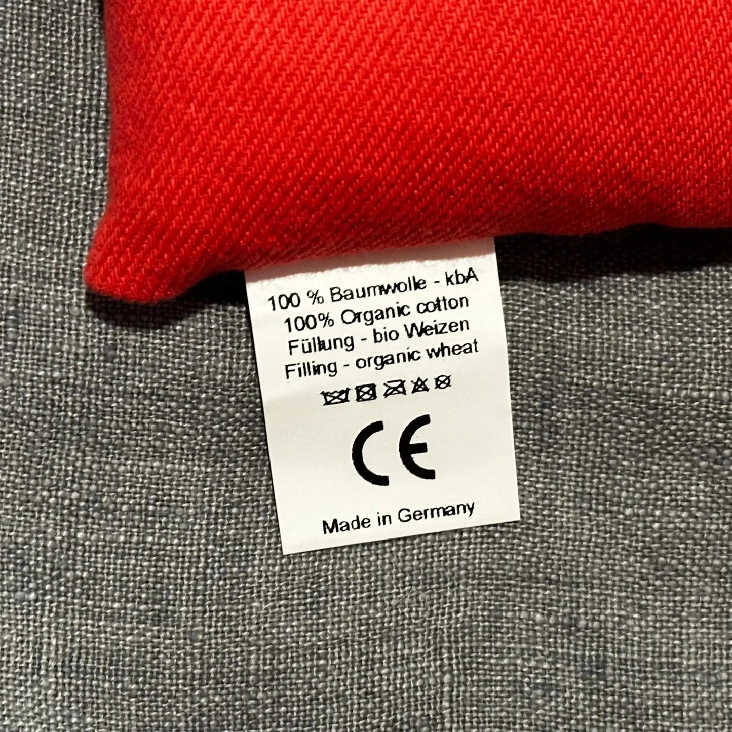 Red bean bag with a close up of the label on a gray surface