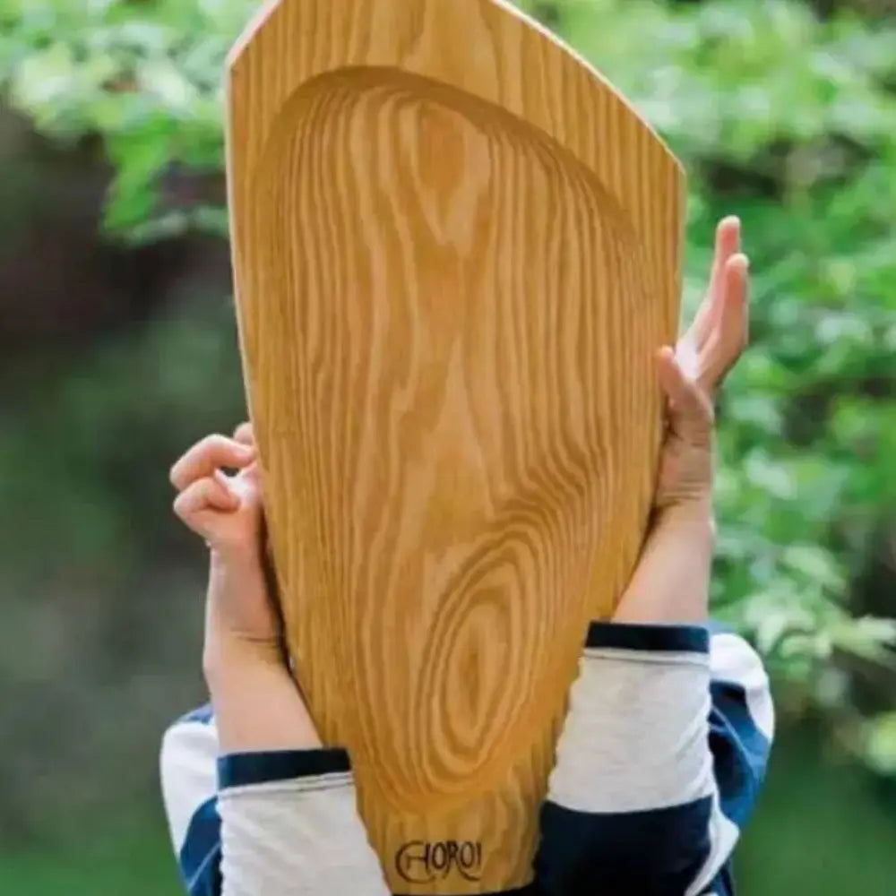 Child holding a Choroi Kantele Zither Lap Harp with an outdoor greenery background