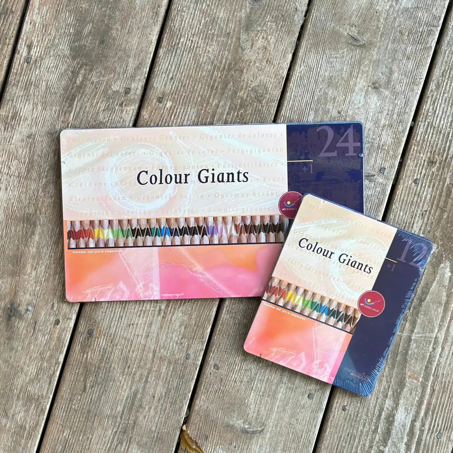Two packages of Colour Giants colored pencils on a wooden surface