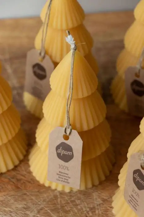 Several beeswax Christmas Tree Candles with kraft Dipam tags