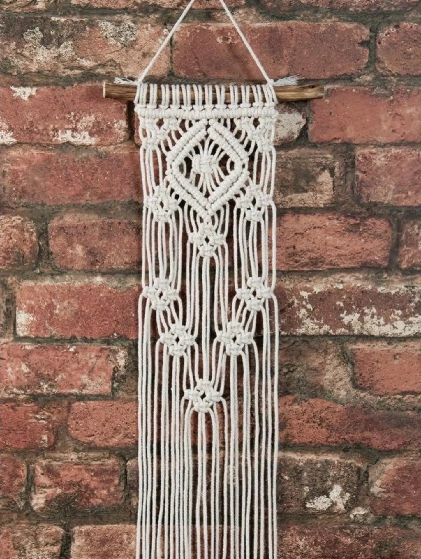 Macrame wall hanging against a brick wall