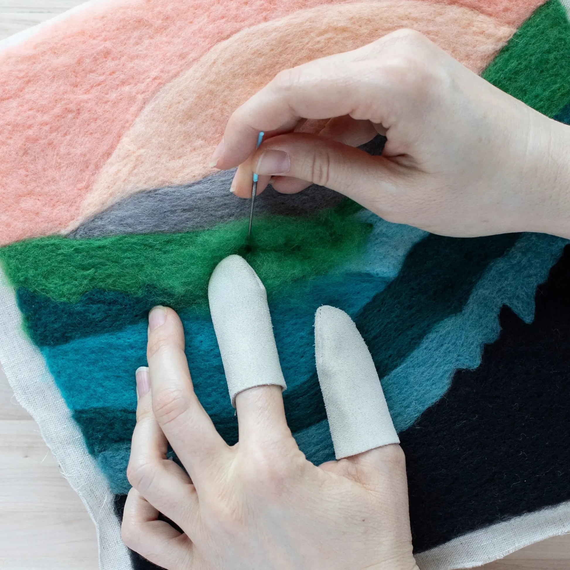 Hands wearing Needle Felting Finger Guards while Needle Felting