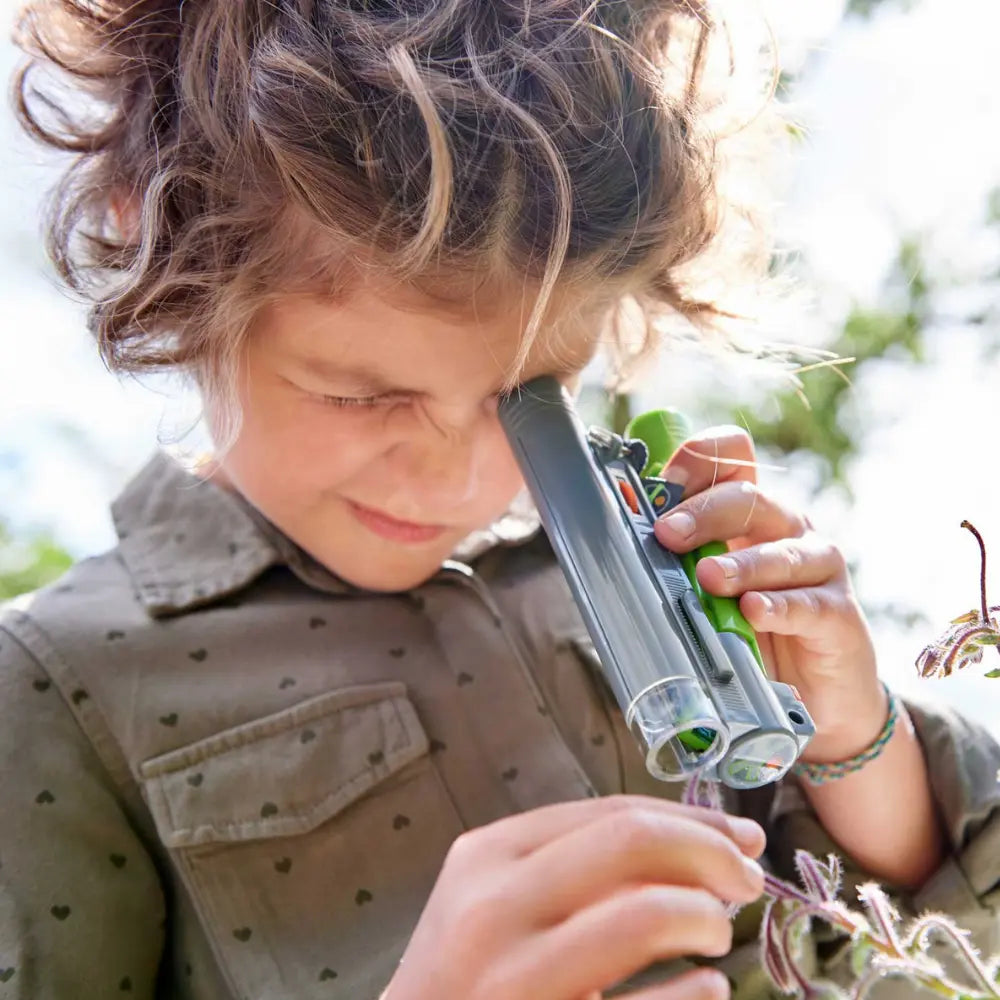 Child using a small field microscope outdoors