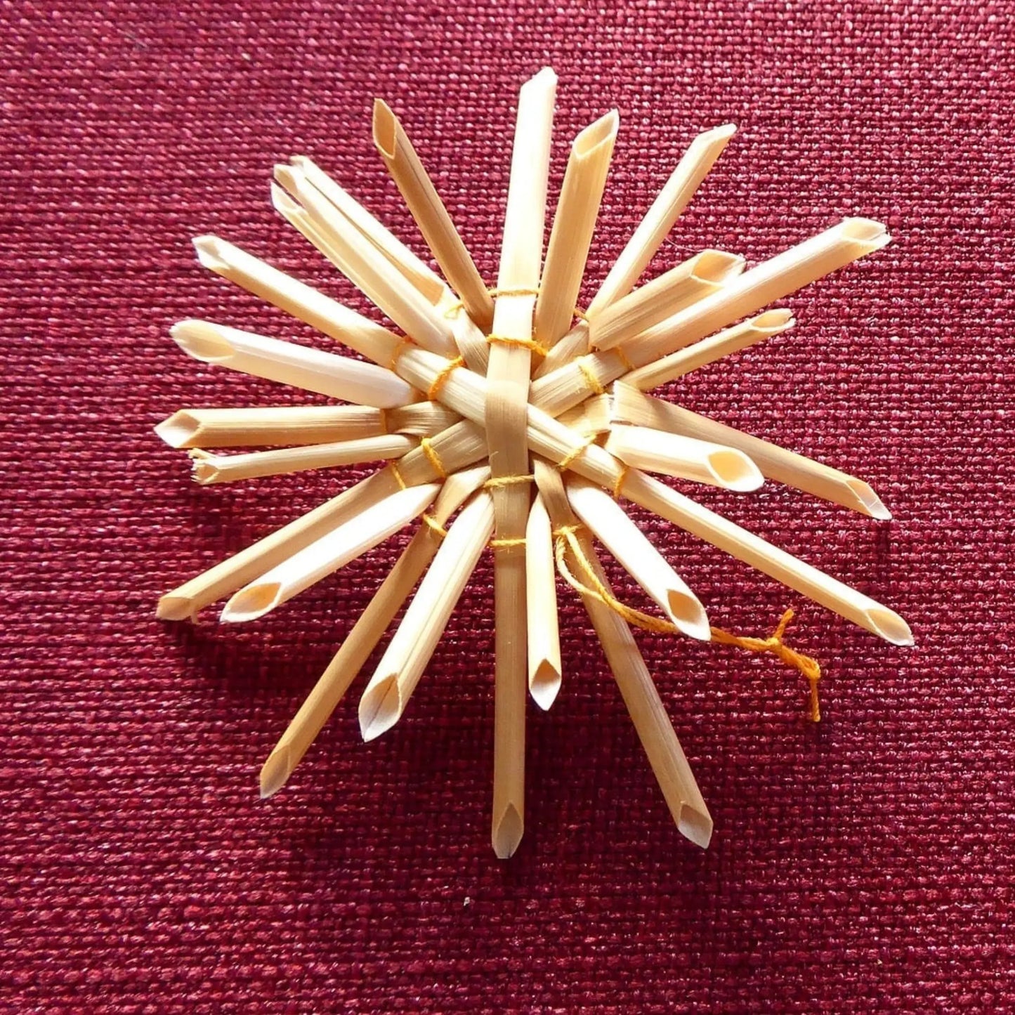 Decorative item made of wooden sticks on a red fabric background