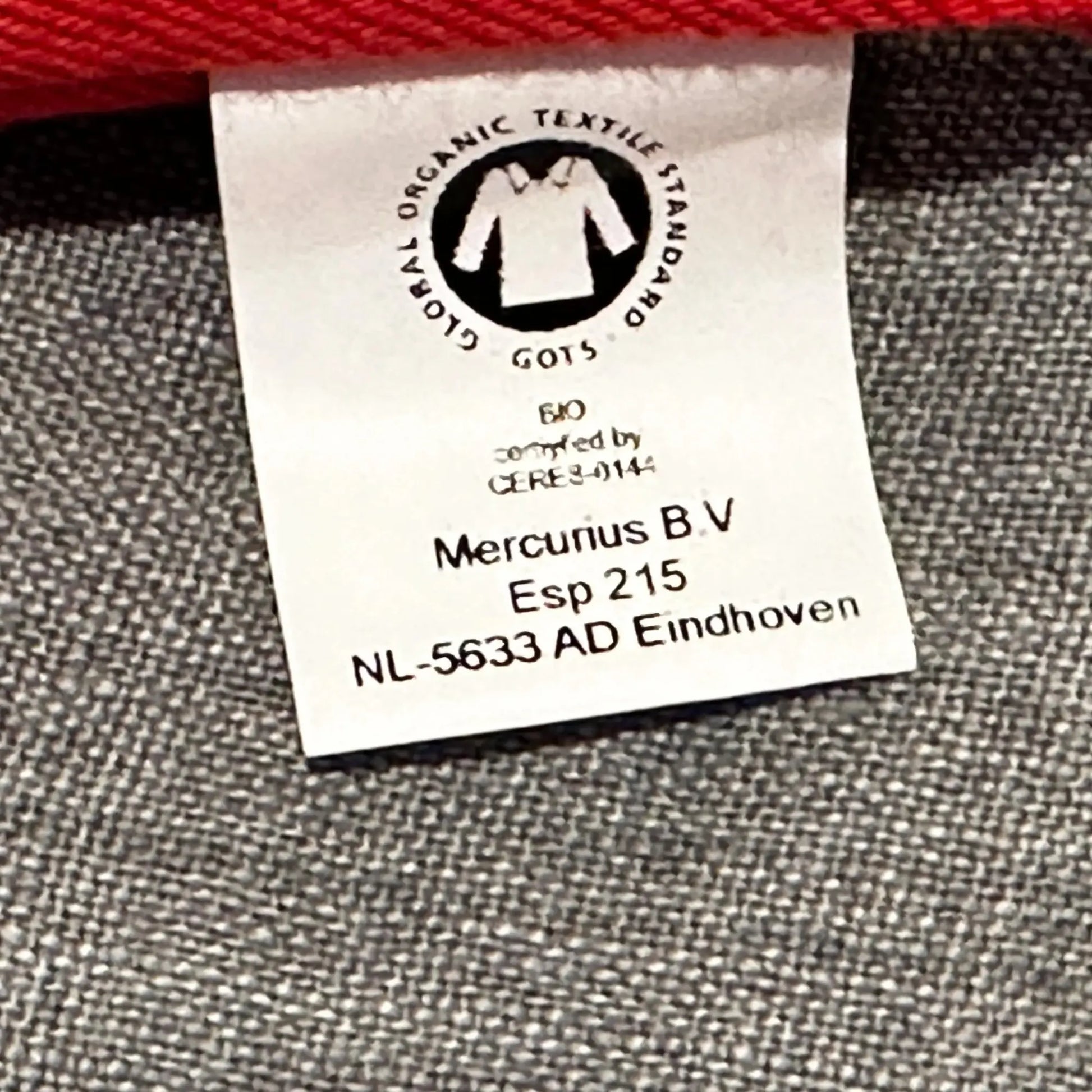Red bean bag with a close up of the label on a gray surface