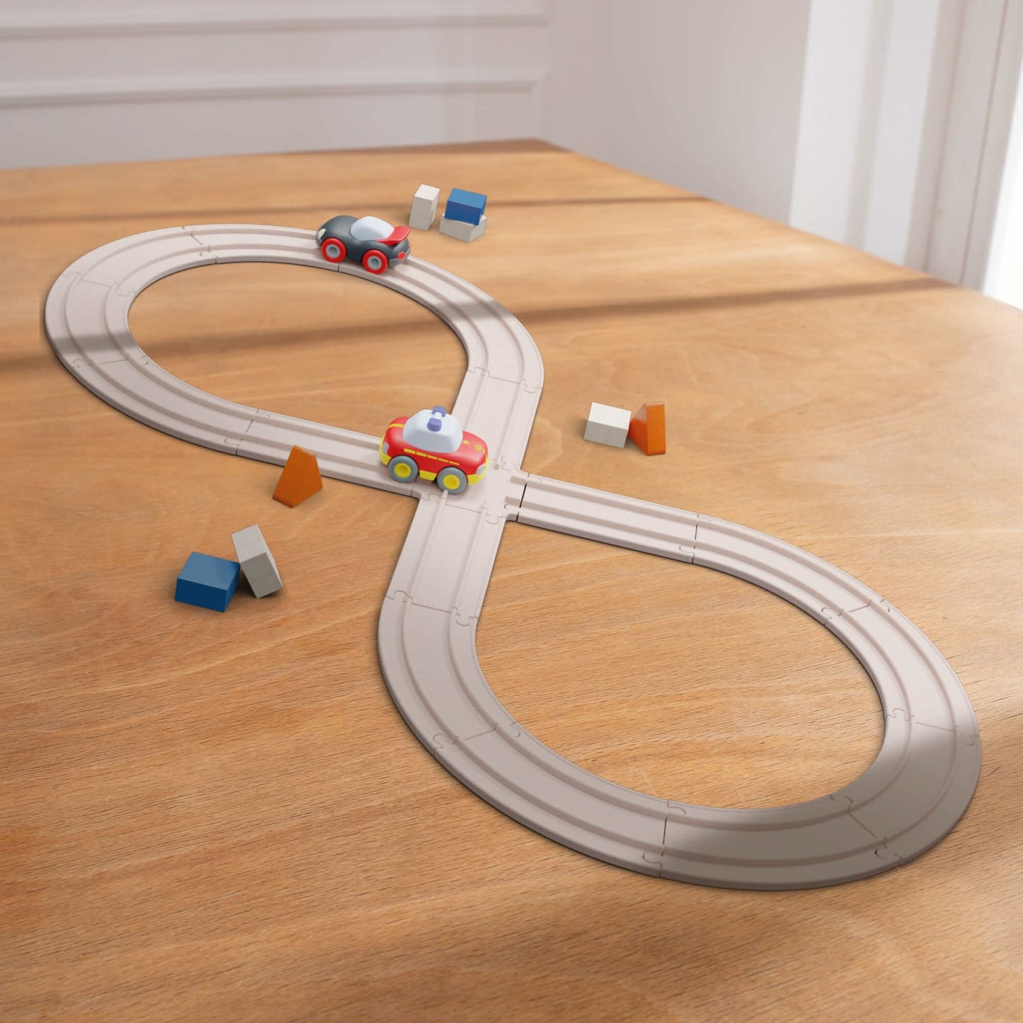 Toy train set on a wooden surface with a track and small cars.