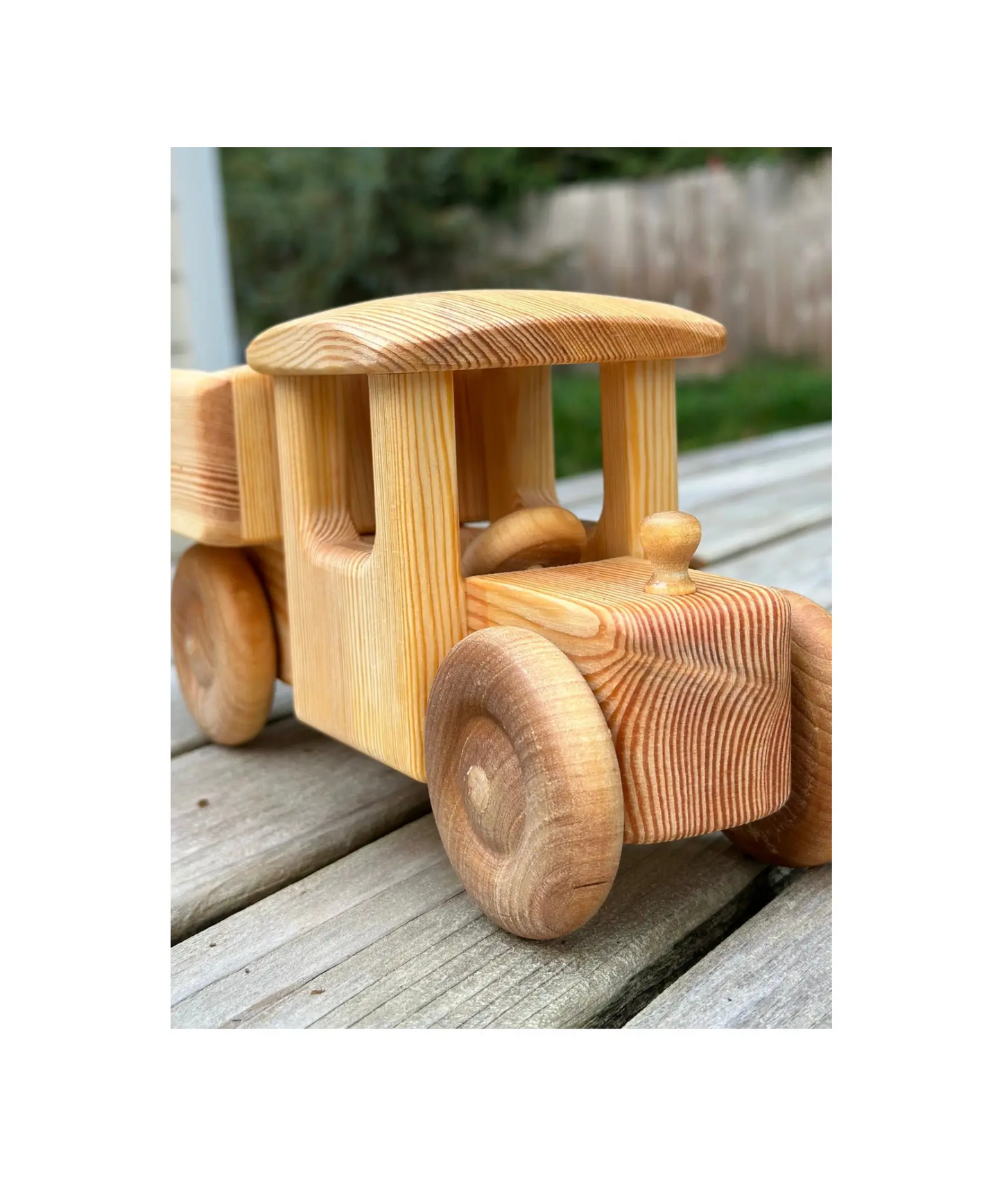 Wooden toy truck on a wooden surface with a blurred natural background