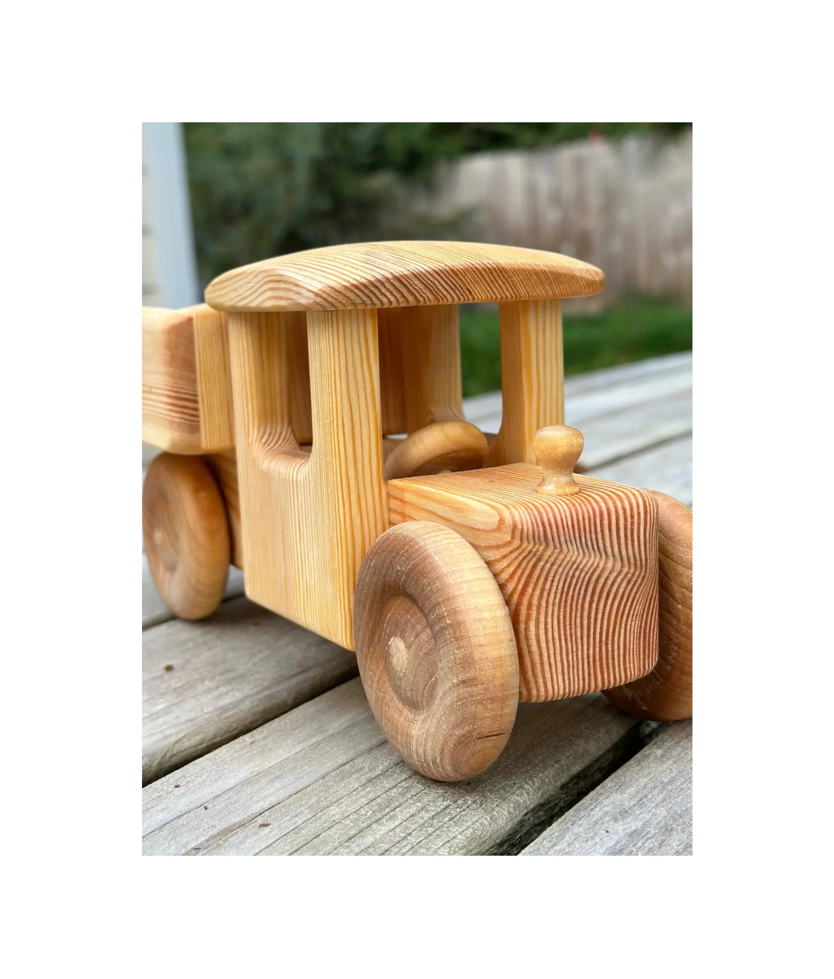 Wooden toy truck on a wooden surface with a blurred natural background