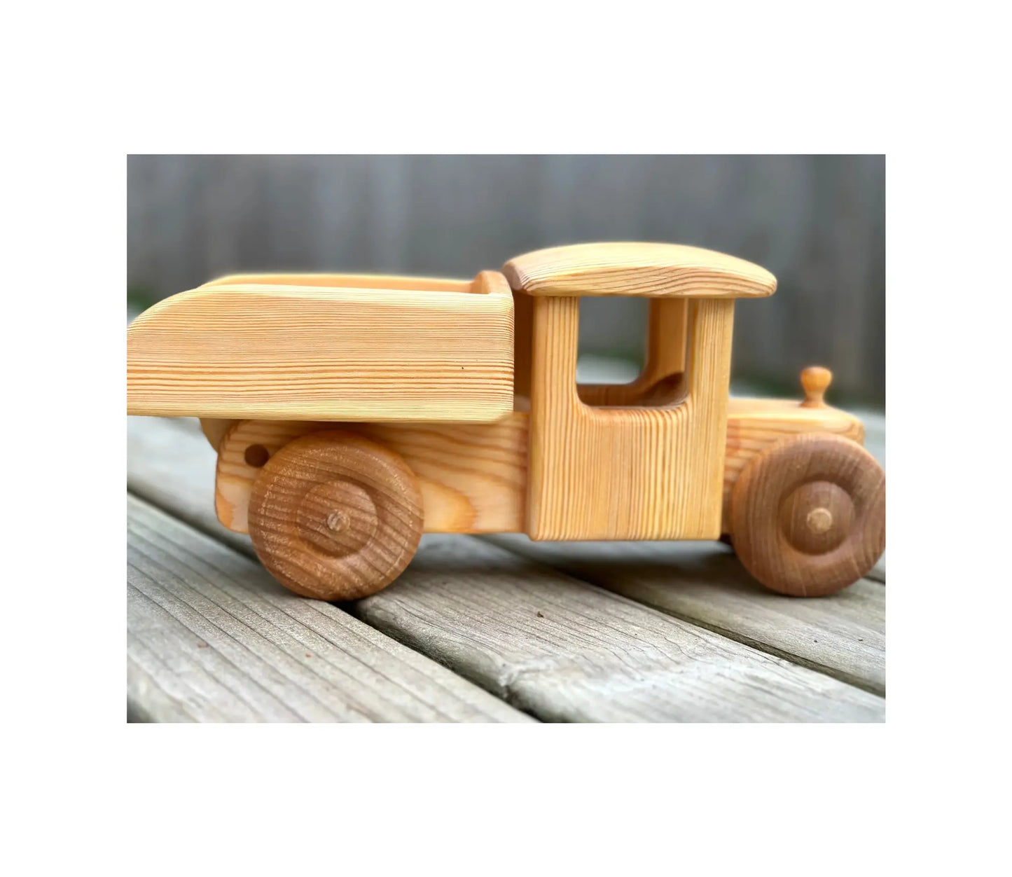 Wooden toy truck on a wooden surface with a blurred background