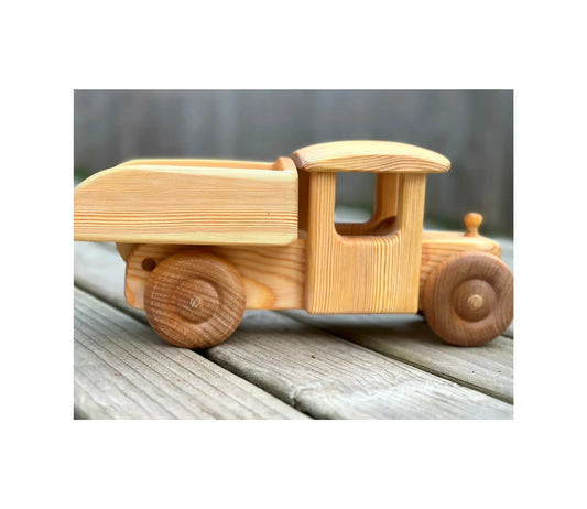 Wooden toy truck on a wooden surface with a blurred background