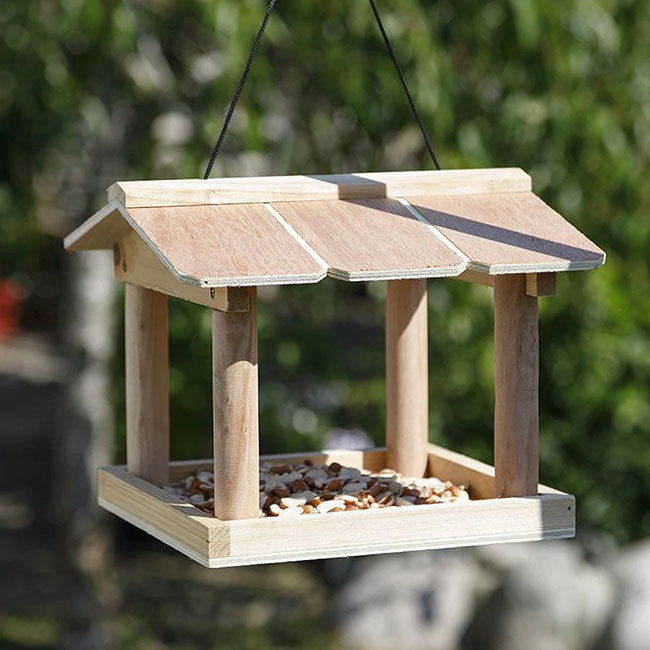 A DIY bird feeder kit made of precut wooden panels, with hardware included for assembly. The feeder is designed to be hung and has a compartment for seeds.