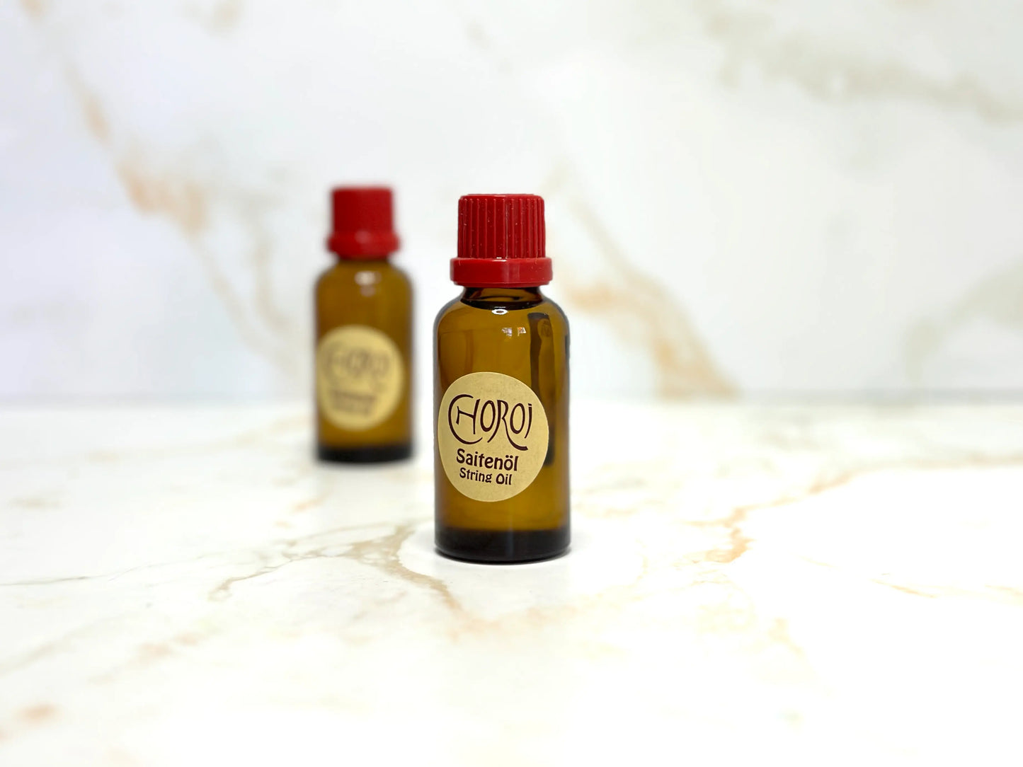 Two bottles of String Oil by Choroi for String Instruments on a white background