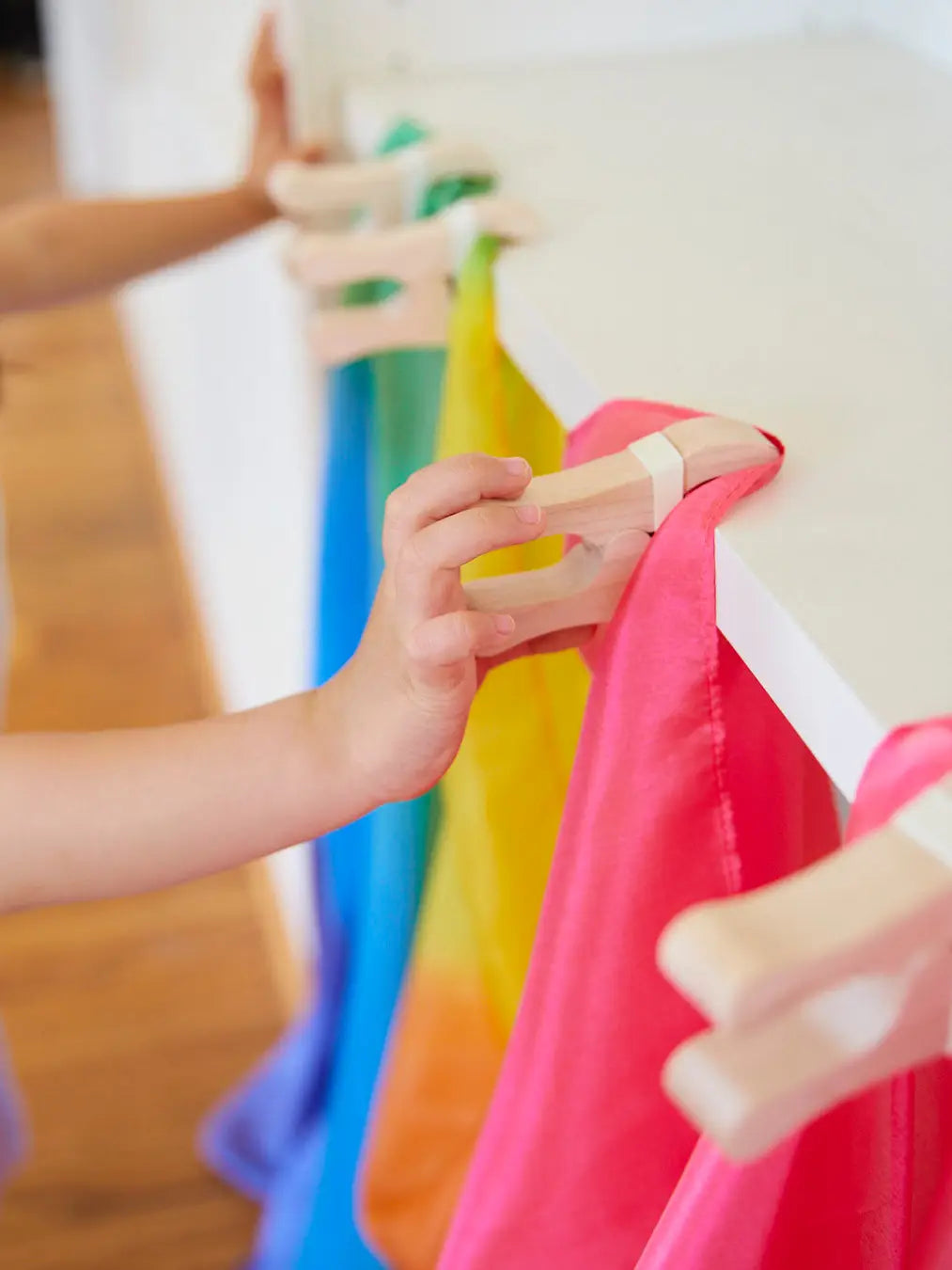 Sarah’s Silks Playcloth Clips holding up red and blue playsilks