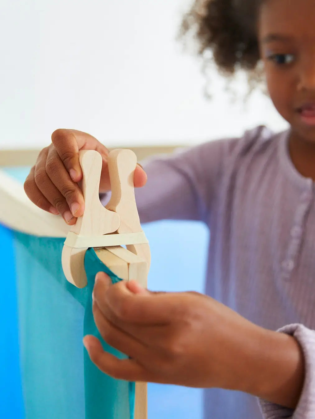 Child playing with Sarah’s Silks Playcloth Clips