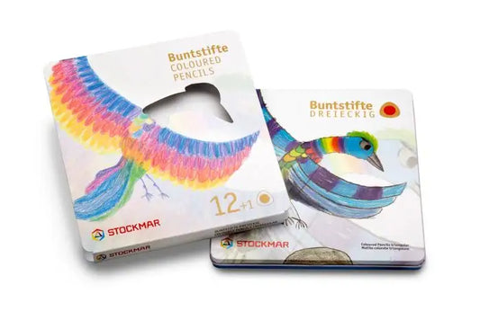 Two Stockmar color pencils metal tin with colorful bird on front on white background