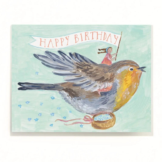 Birthday card with a robin holding a banner and a girl on its back, on a light blue background.