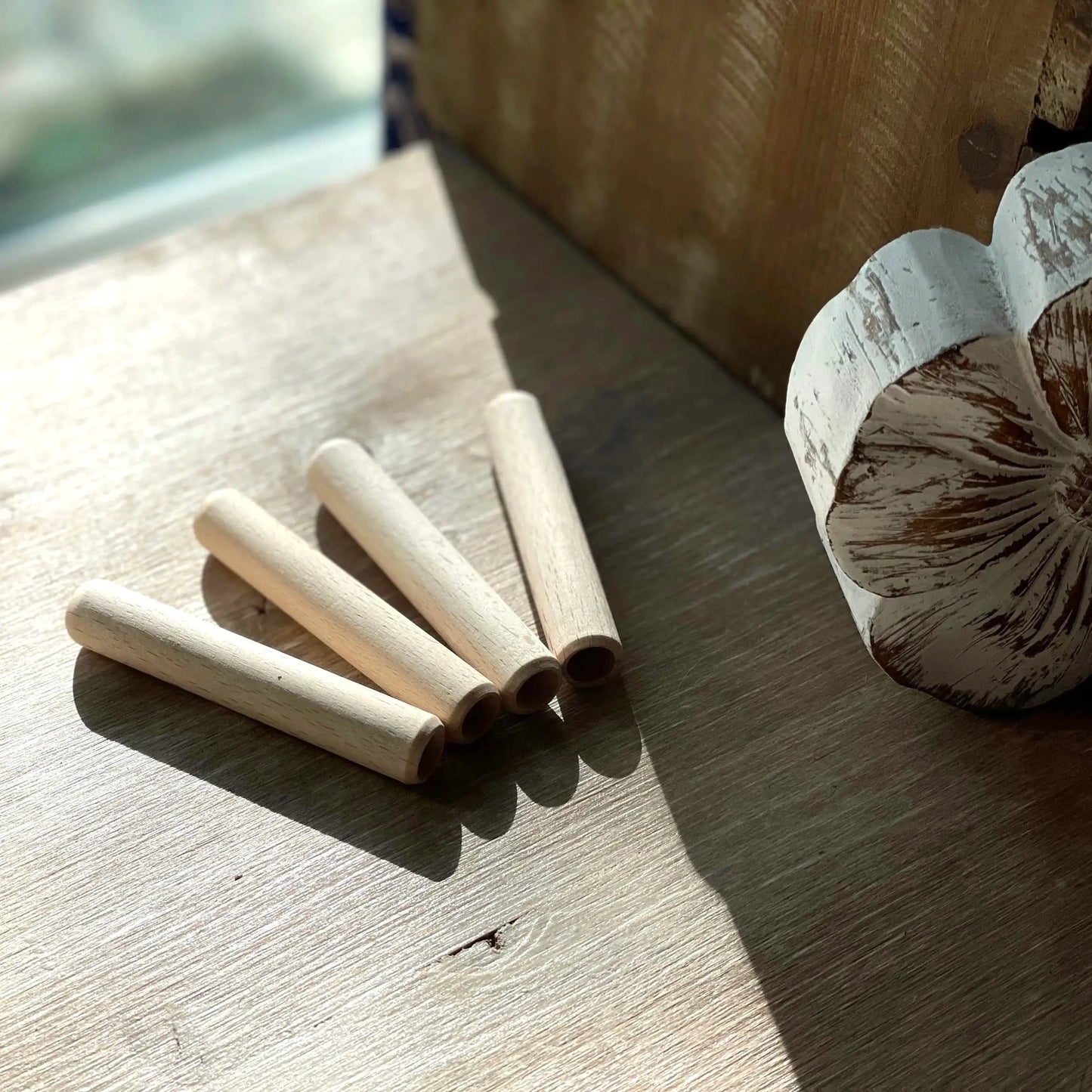 Wooden pencils extenders on a wooden surface with a rustic background