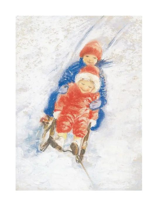 Two children in blue and red snowsuits and hats sledding down a snowy hill.