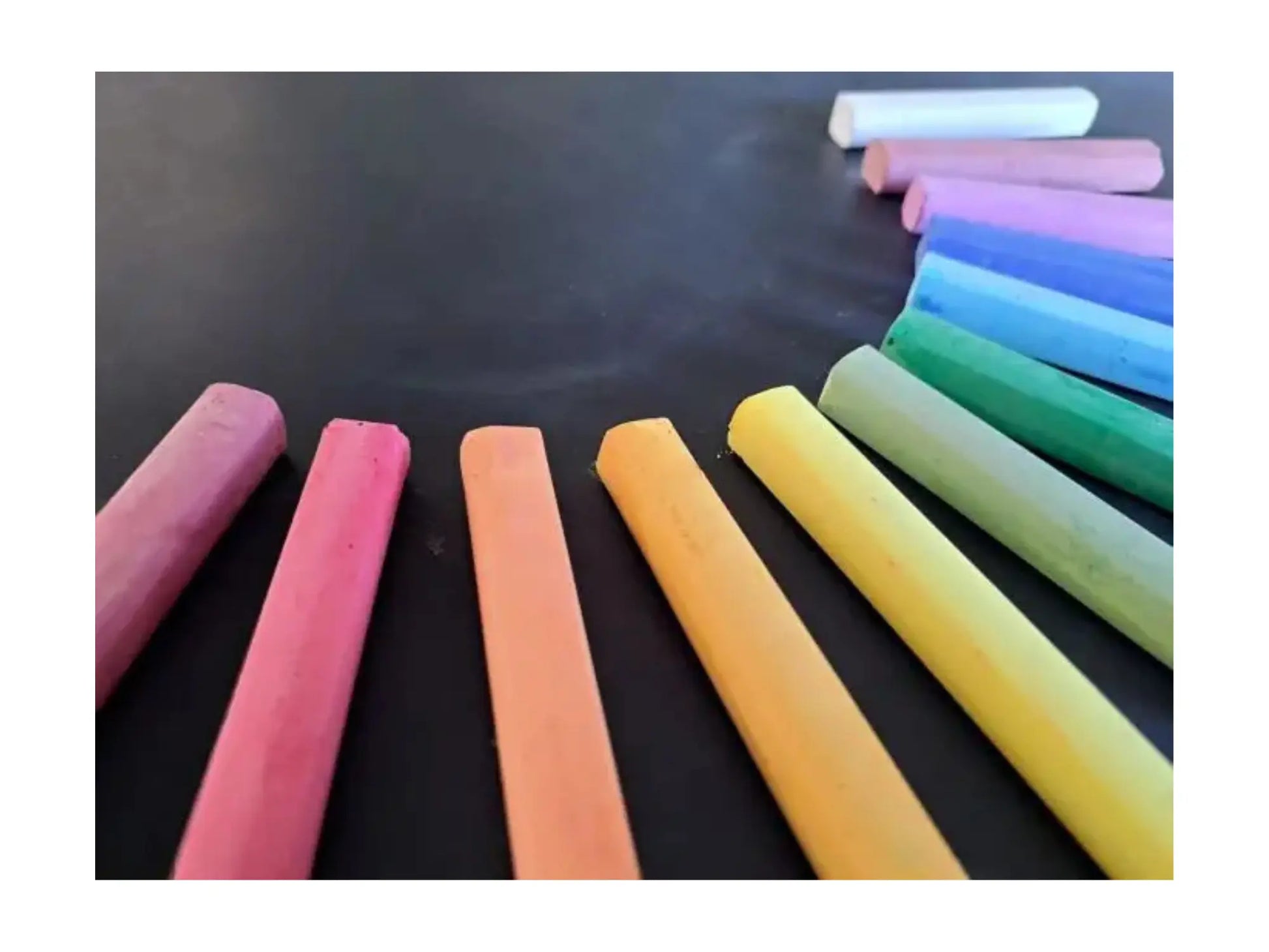 Assorted colorful chalks on a black surface