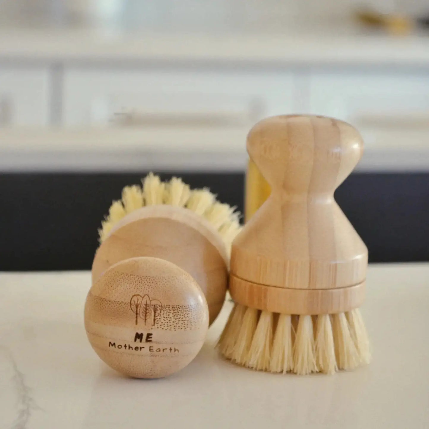 Set of wooden cleaning brushes with natural bristles on a marble surface.