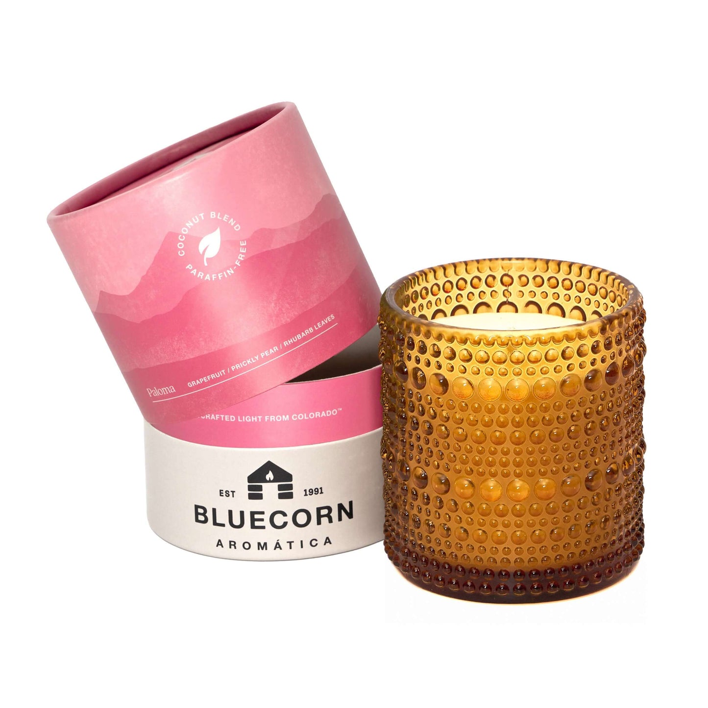 Orange textured candle in a pink and white Bluecorn Aromatica packaging on a white background