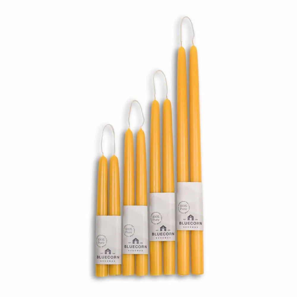 Set of yellow candles with white wicks on a white background, branded 'Bluecorn'.