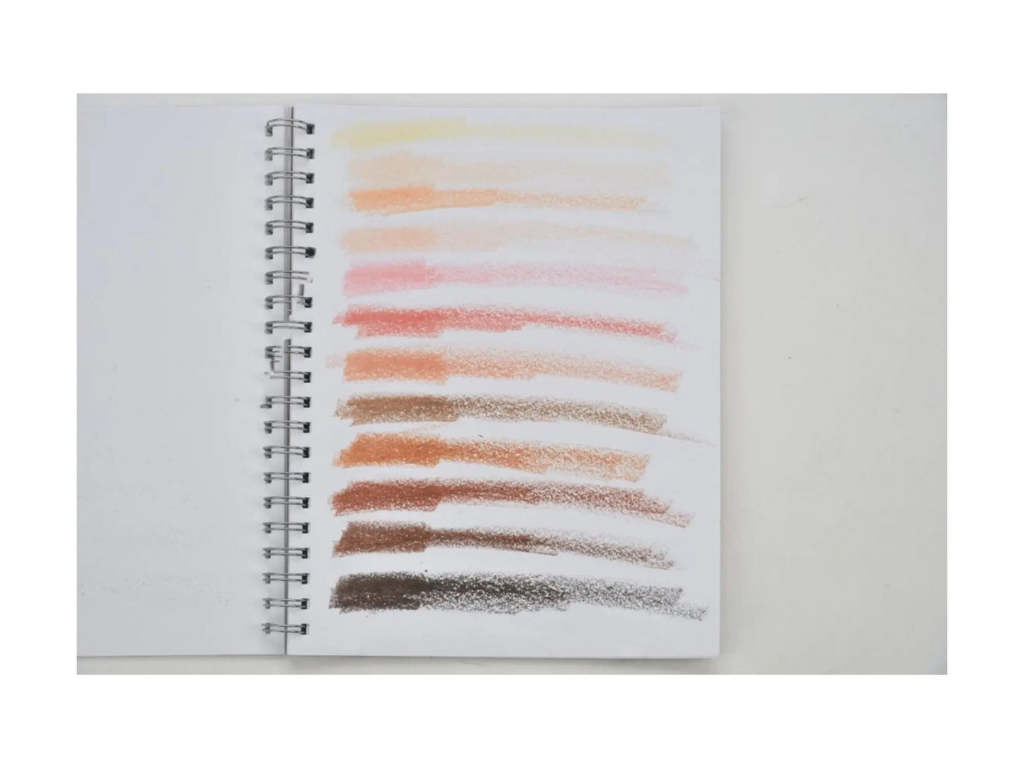 Spiral-bound notebook with colored pencil swatches on a white background