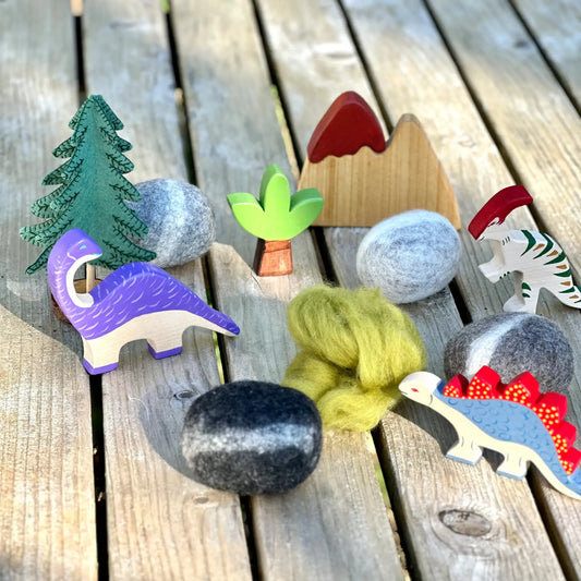 Colorful wooden dinosaur toys and natural elements on a wooden surface