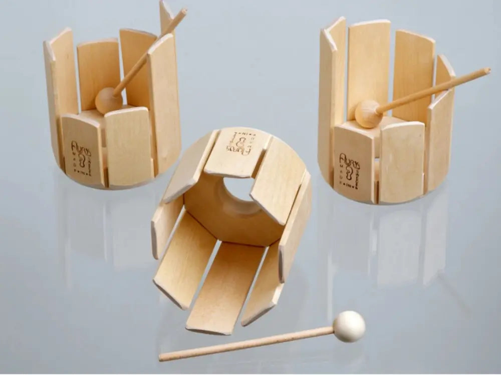 Three wooden hand drums with mallets on a reflective surface