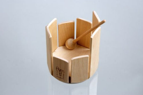 Wooden stir drum xylophone musical instrument with a mallet on a light blue background