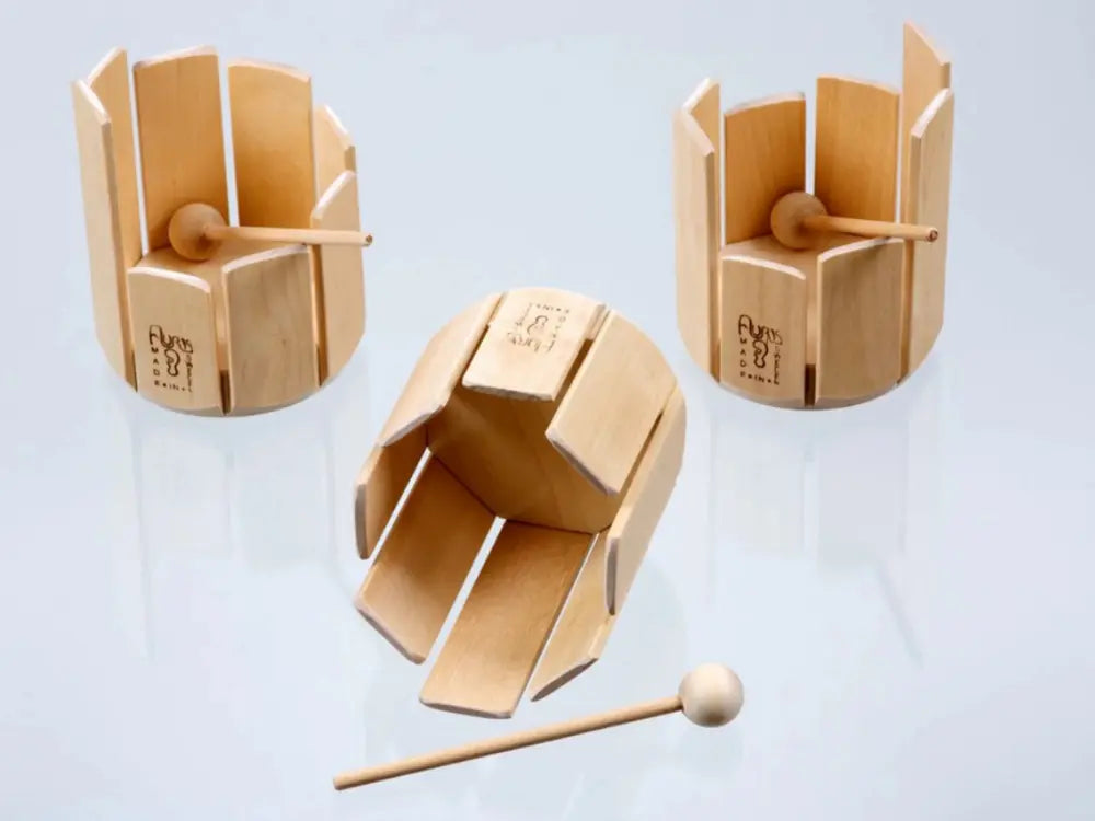 Wooden stir drum xylophone musical instrument with a mallet on a light blue background