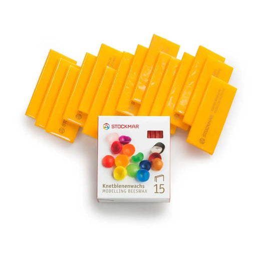 Yellow beeswax bars with Stockmar packaging on a white background