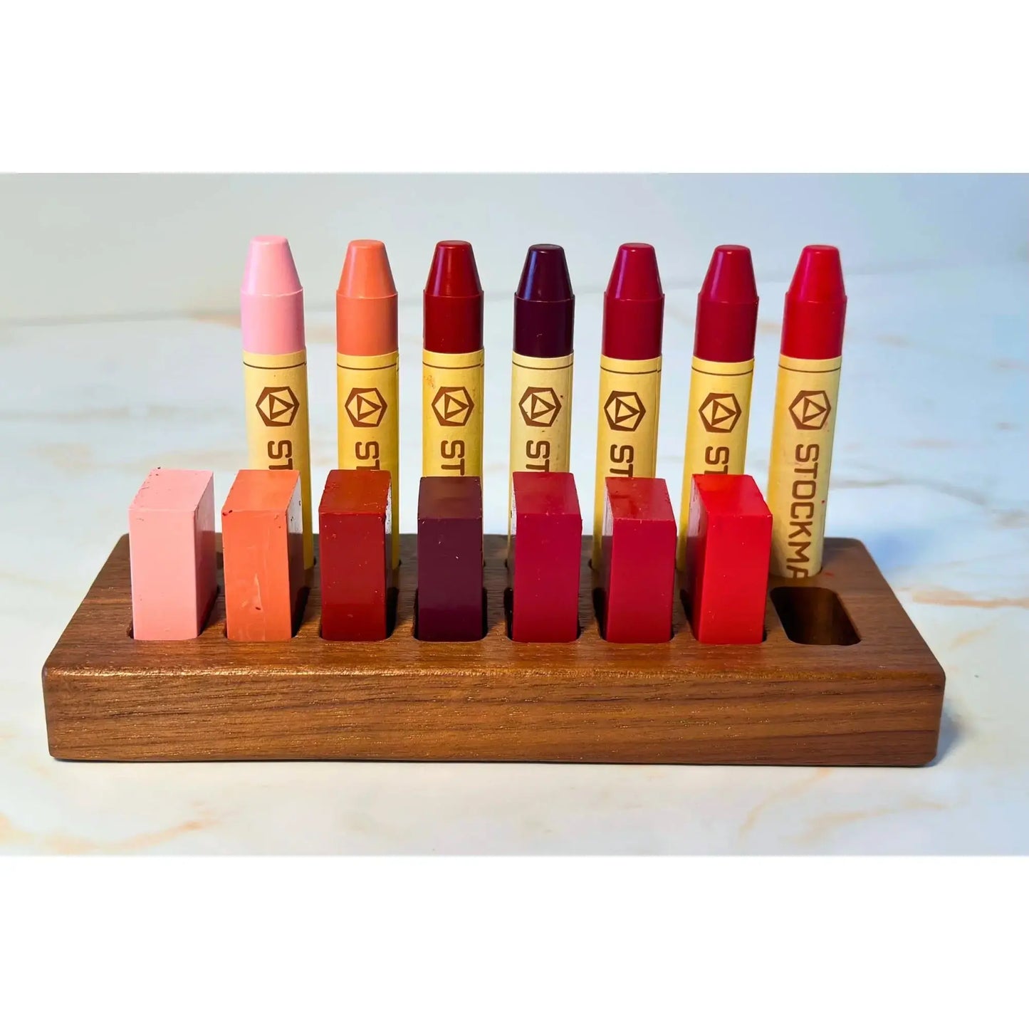 Set of colorful Stockmar doll blush crayons in a wooden holder on a light background