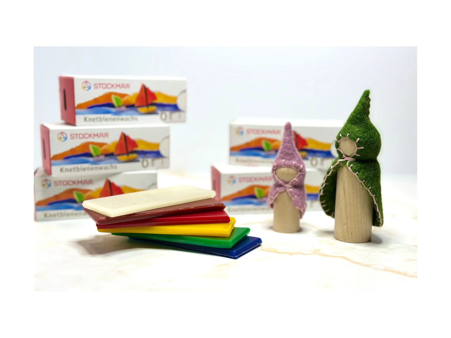 Stockmar Modeling Beeswax stacked next to wooden and felt gnome dolls