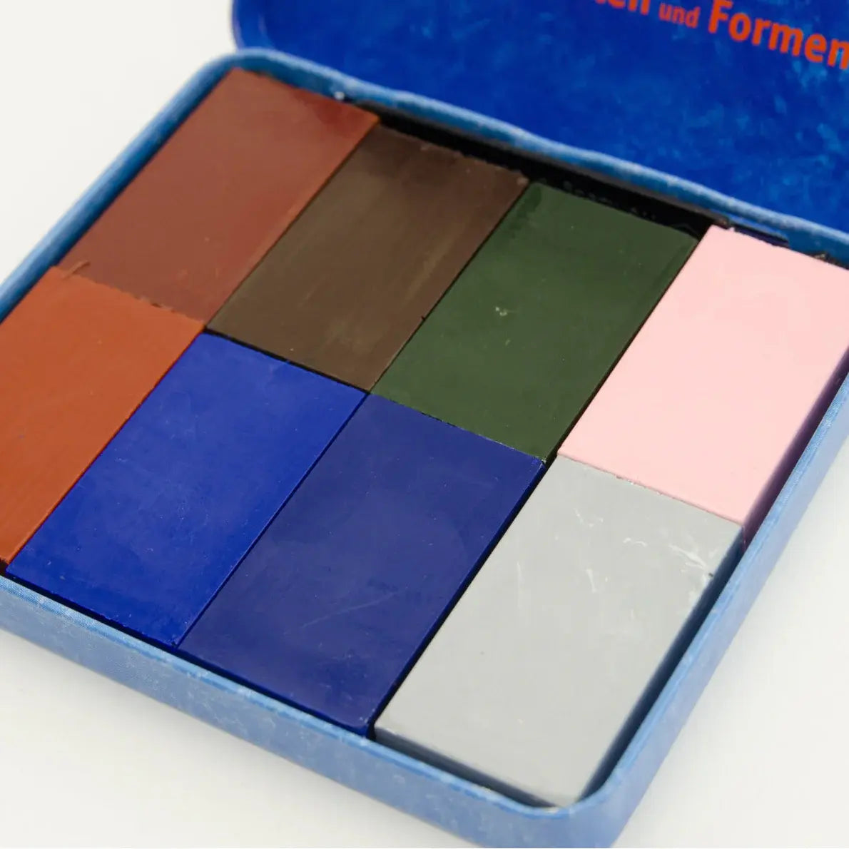 Set of colored square beeswax crayon blocks in a blue box