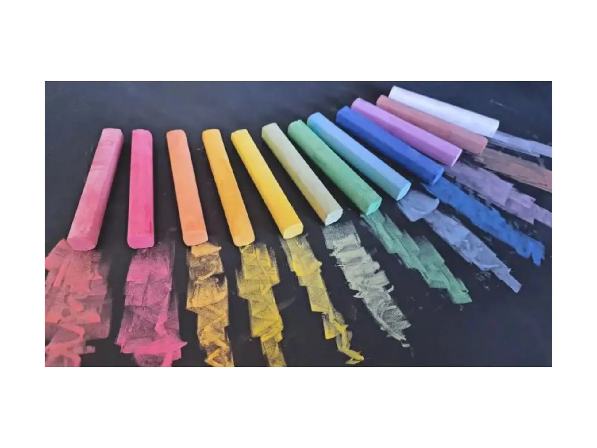 Assorted colorful chalks on a black background
