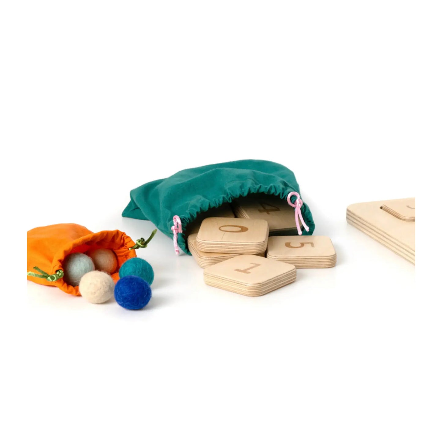 Wool felt balls and wooden number tiles stored in cotton drawstring bags for Montessori and Waldorf-inspired wooden quantity board