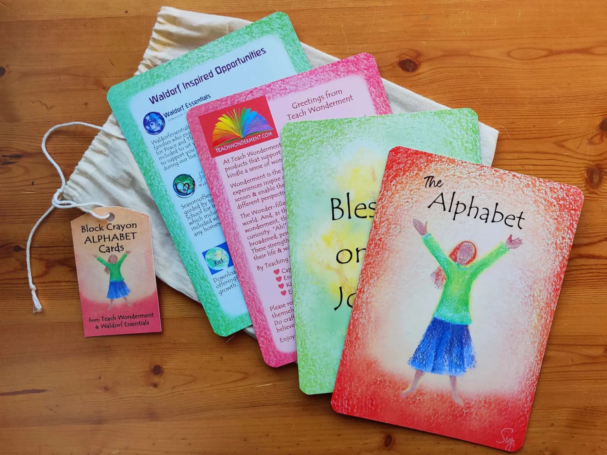 Waldorf Block Crayon Alphabet Card Set Fanned out over a wooden tabletop