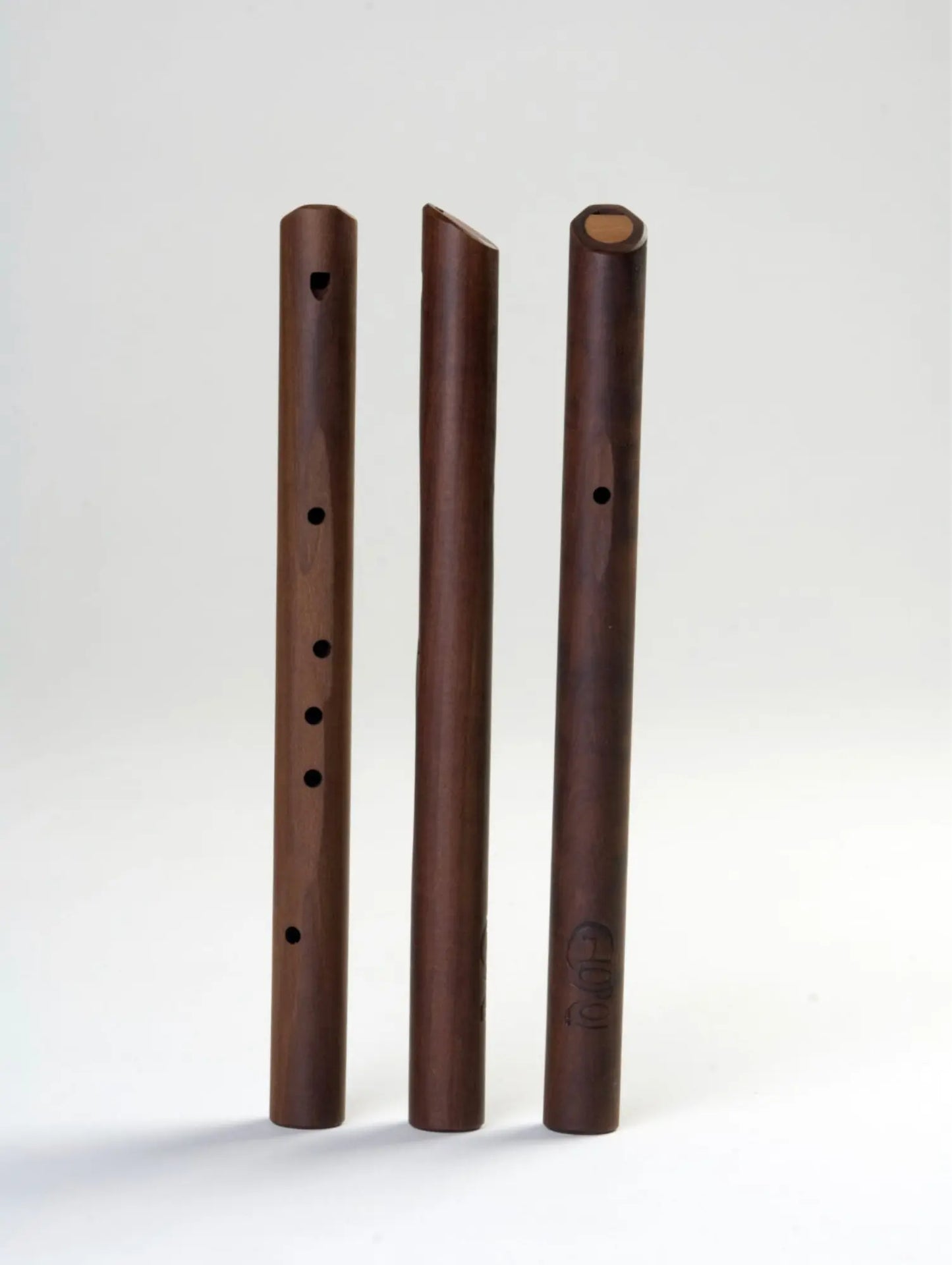 Three wooden flutesside by side with Choroi logo on one on a gray-white background