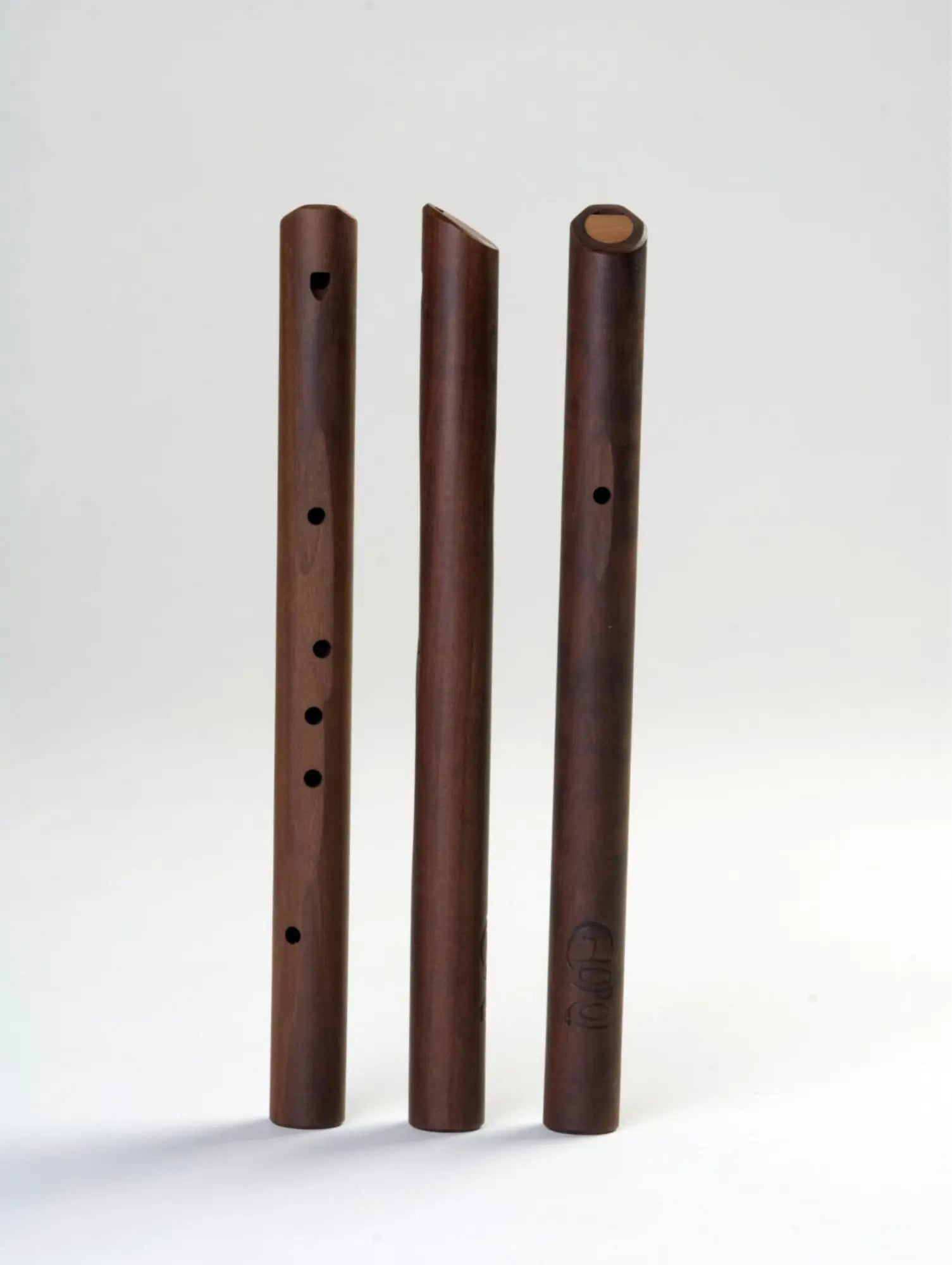 Three wooden flutesside by side with Choroi logo on one on a gray-white background