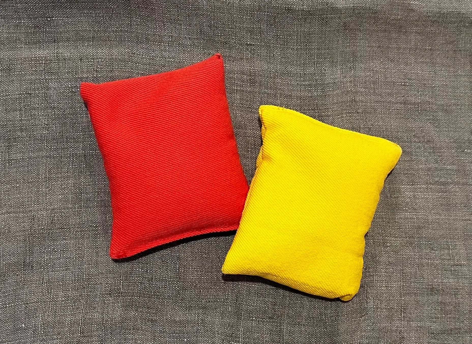 Red and yellow bean bags on a gray textured background