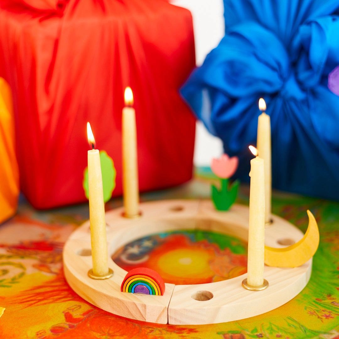 Wooden Birthday Ring with lit candles on a colorful surface