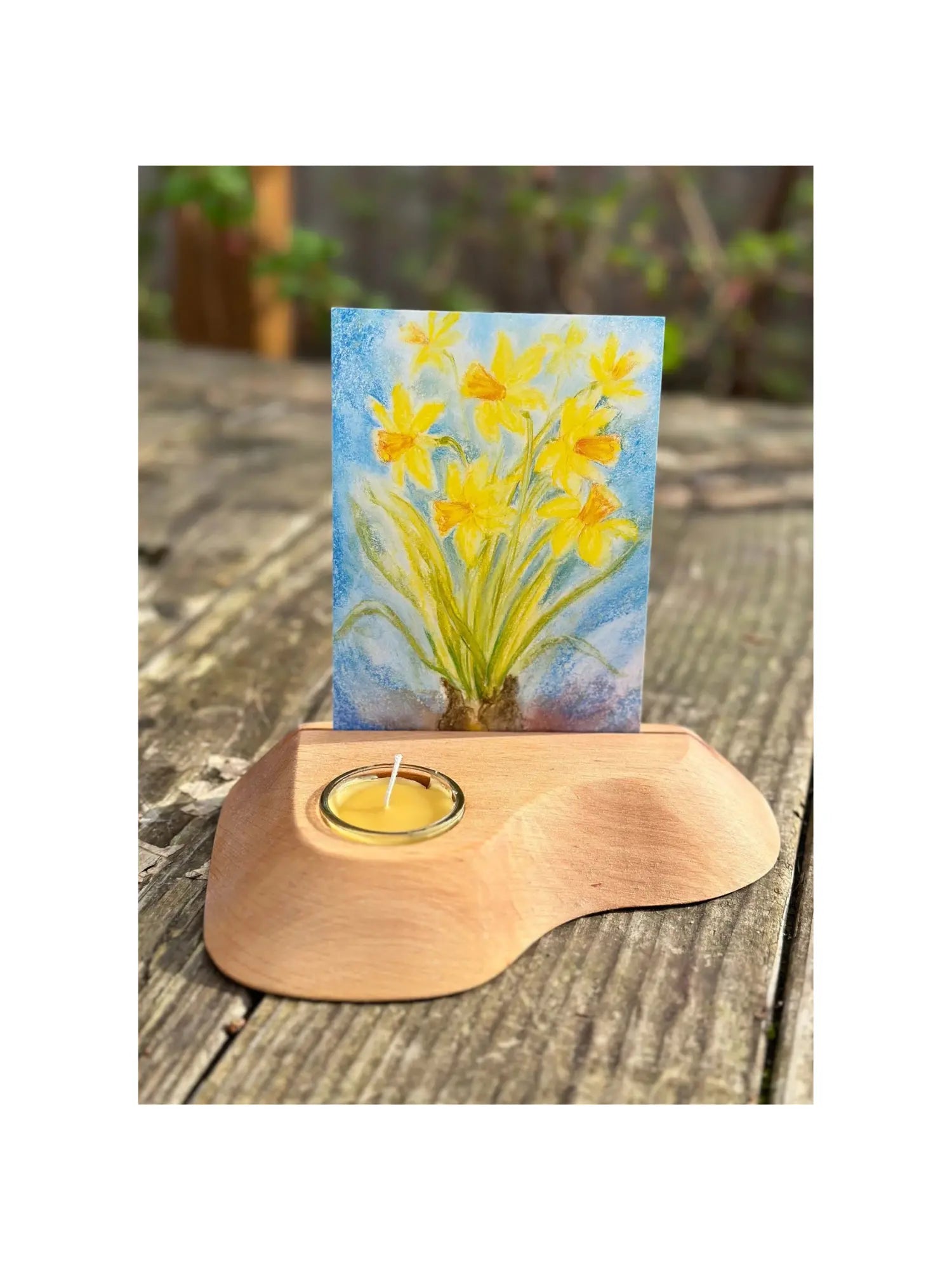 Alderwood Photo and Postcard Holder with Tealight and a postcard of daffodils on rustic outdoor wooden table