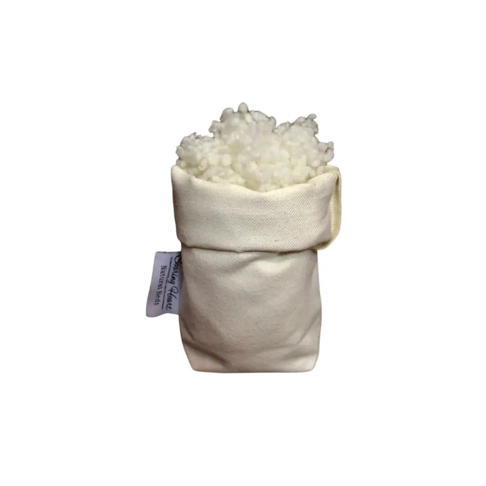 White cotton bolus in a natural fiber bag on a white background