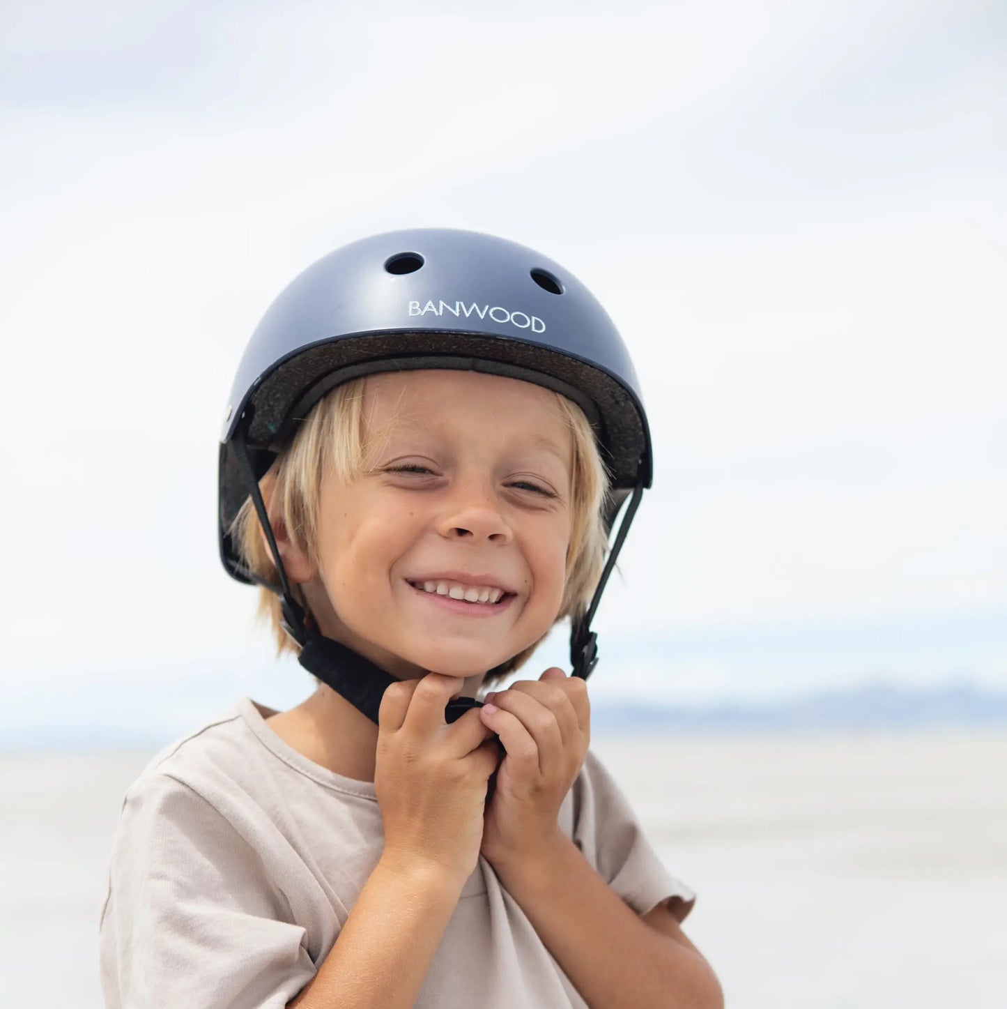 Child wearing a navy blue helmet with Banwood branding against a light background